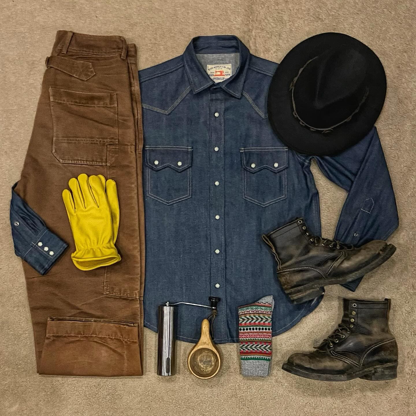Workwear style outfit with brown pants, denim shirt, boots, and accessories